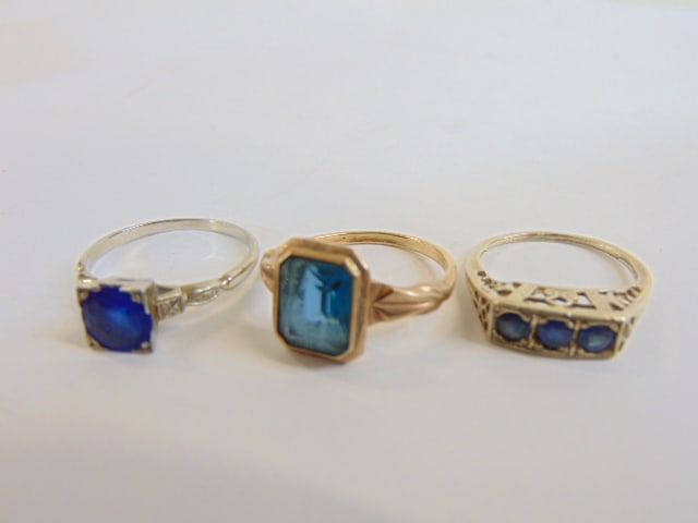 Jewelry. (3) gold rings to include 18kt white gold w/ round blue stone in square setting size 9, (1 of 5)