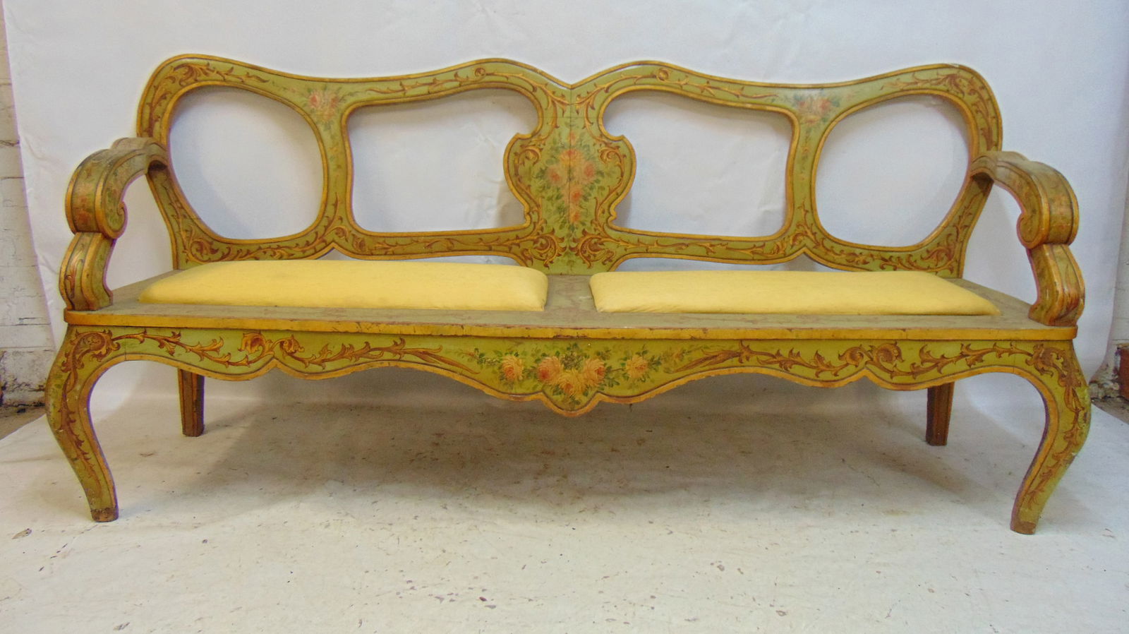 Paint decorated bench, in green paint with floral painted decoration, has two upholstered seats, (1 of 7)