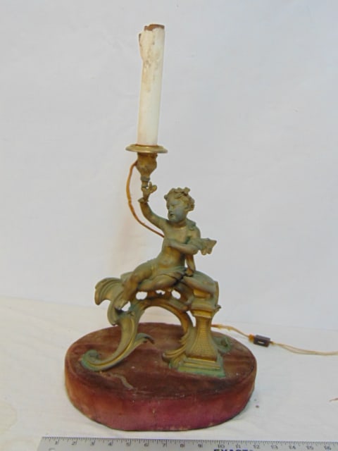 Bronze figural lamp, putti holding socket, ornate base, lamp is 23" tall, base (covered fabric) is: Bronze figural lamp, putti holding socket, ornate base, lamp is 23" tall, base (covered fabric) is 9.5" by 12.5"