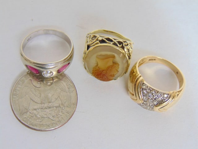 Jewelry. 3 Gold rings. 14k white gold band w/ small central diamond flanked by two pink/red stones, (1 of 5)