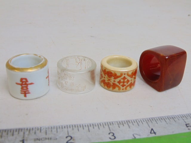 4 Chinese archer rings, 2 porcelain with decoration, characters, one glass or translucent stone (?) (1 of 11)
