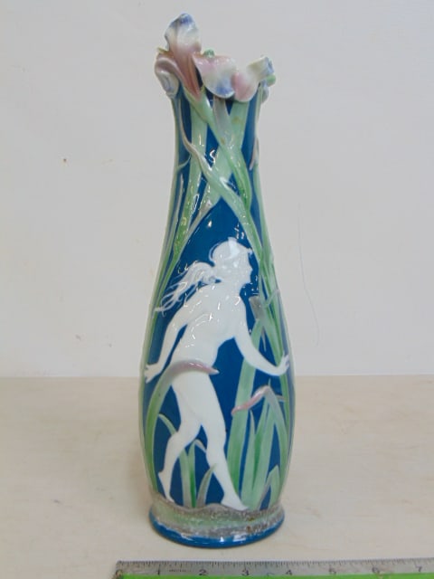 Pat sur pat vase by Gebruder Heubach, figure walking in tall grass, as is, piece of rim missing,: Pat sur pat vase by Gebruder Heubach, figure walking in tall grass, as is, piece of rim missing, small hairline, height is 12.75"