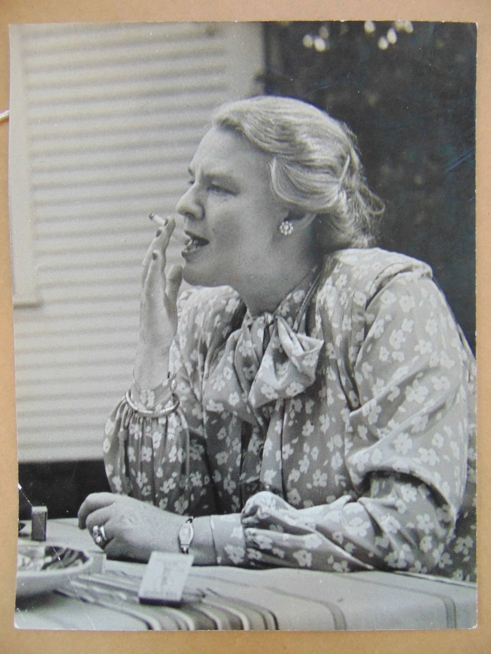 Photograph by Elli Marcus, woman in floral dress smoking a cigarette, stamped on reverse, 9 5/8" (1 of 4)