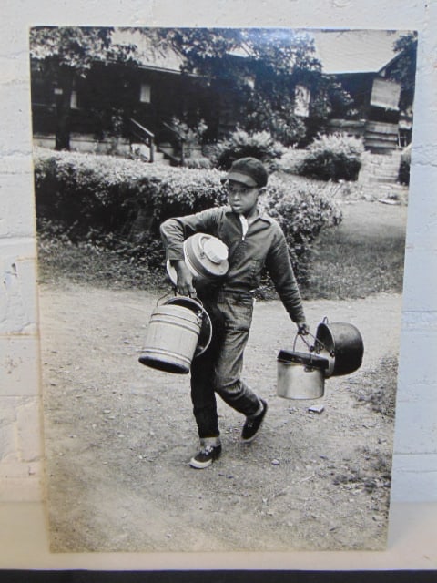Photograph, Guy Gillette, young black boy carrying pots & poans, dated 1975, 16.75" by 11 3/8", # (1 of 3)
