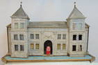 Large rustic birdhouse, folksy house with formal facade flanked by two towers, old paint, base is