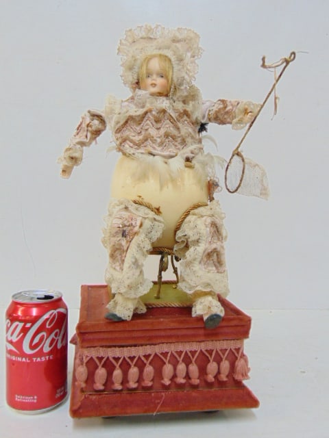 Automaton, girl with egg body, holding net, on velvet base, works, height is 17", not old: Automaton, girl with egg body, holding net, on velvet base, works, height is 17", not old