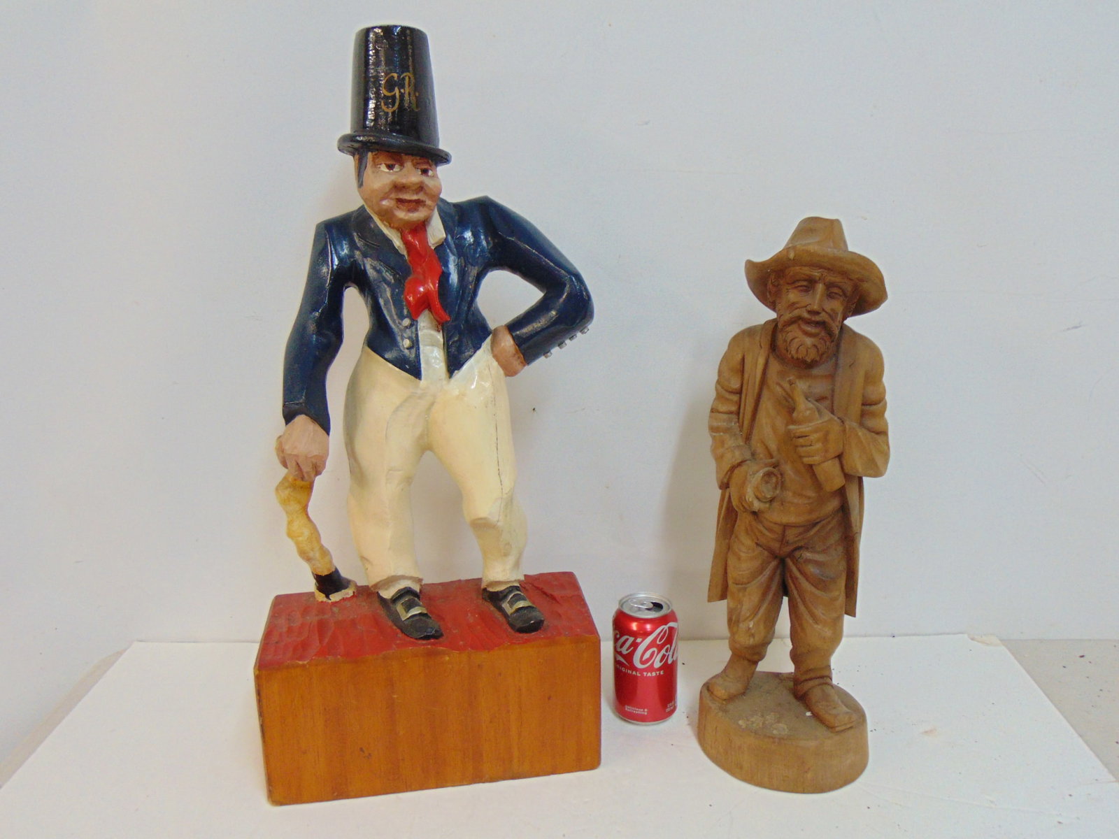 2 wood carvings, one painted, bearded man with bottle of wine height is 20" and carved figure of a: 2 wood carvings, one painted, bearded man with bottle of wine height is 20" and carved figure of a man with cane, tall hat, painted, height is 26"