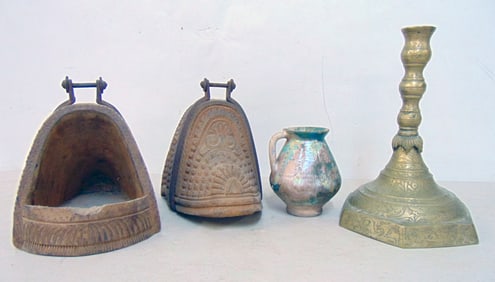 Persian lot, carved wood stirrups, early pottery single handle vase & brass candlestick, pottery has