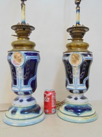 Pair porcelain & brass table lamps on painted wood bases, decorated with protruding heads (one has