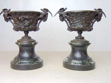 Pair bronze garnitures, urns on marble bases, decorated with grapes, vines and birds seated on rim,