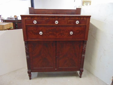 Empire mahogany chest of drawers with decorative half columns & back splash, left door has damage by