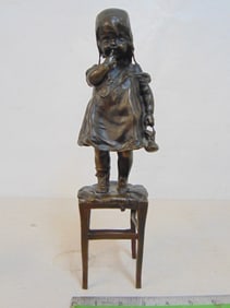 Bronze, girl standing on chair, signed Juan Clara, height is 13 1/8", base is 3.5" by 3.5"
