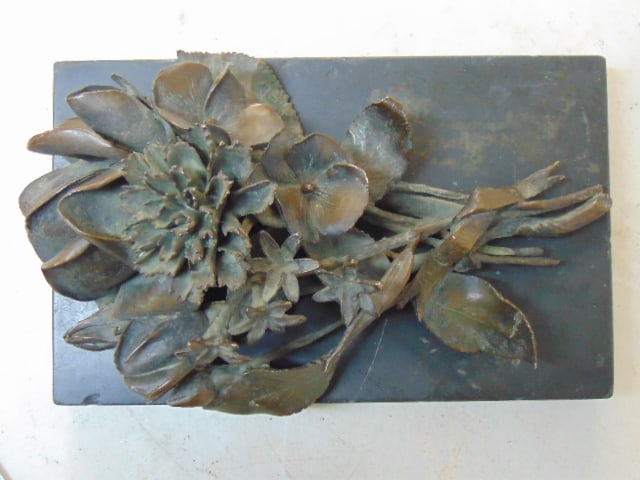 Bronze flower bouquet on slate base, faint writing on ribbon (AVGV ?), 7 3/8" by 4.5"3.5" tall,: Bronze flower bouquet on slate base, faint writing on ribbon (AVGV ?), 7 3/8" by 4.5"3.5" tall, bronze loose on slate.