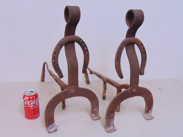 Pair folk art figural andirons with horse shoe decoration, 19" tall, 18" deep, 10" wide.