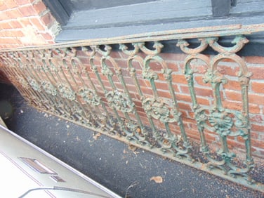 Two sections of cast iron fence, top rail on both is rusted, loose, smaller section has several