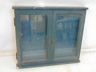 Hanging display case, wood case in blue paint, no shelves, two glass doors, cabinet is 27.25" tall,