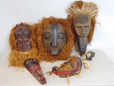 5 African carved wood masks, 2 masks with applied straw (hair), one with straw & feathers & 2 carved