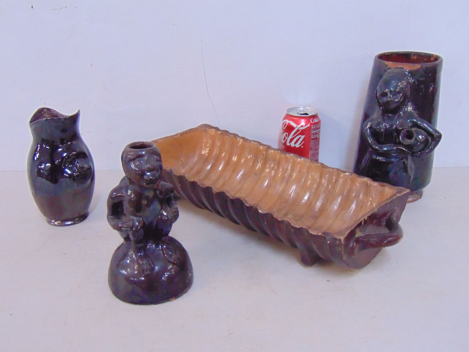 4 pieces redware, mug with figural decoration of a girl with jug; monkey candle holder, partial: 4 pieces redware, mug with figural decoration of a girl with jug; monkey candle holder, partial glazed face pitcher & trough shaped ribbed planter, 16.5" long