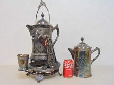 Ornate silver plated tilting water pitcher with cup & additional pitcher, height is 17.75", width is