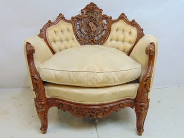 Carved upholstered armchair with elaborate carved back with musical instruments, scrolled arms,