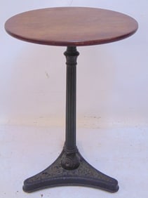 Small stand on decorative cast iron base with round wood top, diameter top is 14.75", height is