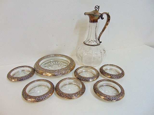Glass wine coasters & carafe with silver rim, handle, includes 6 wine glass coasters & one large: Glass wine coasters & carafe with silver rim, handle, includes 6 wine glass coasters & one large bottle coaster plus carafe, carafe is 10" tall, coasters are 3.75"