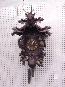 Black forest Cuckoo clock with deer carved top, case decorated with game, one weight does not hold,