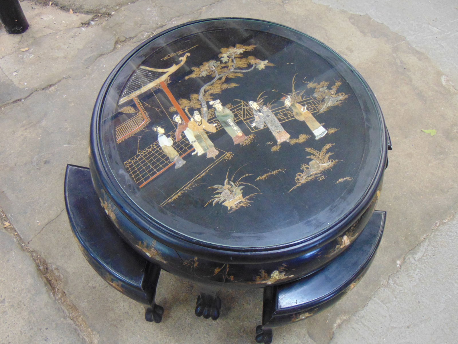 Asian table with 4 small stools, inlaid with carved stone scenes, figures, glass top, labeled "Hong (1 of 7)