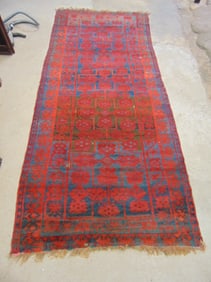 Carpet in red, possibly Afghan, red with black designs, rug is 11'2" by 4'10"