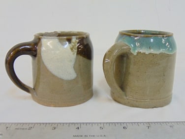 2 Japanese stoneware mugs attributed to Hamada Shoji, unsigned, one has large chip on rim, 3.75"