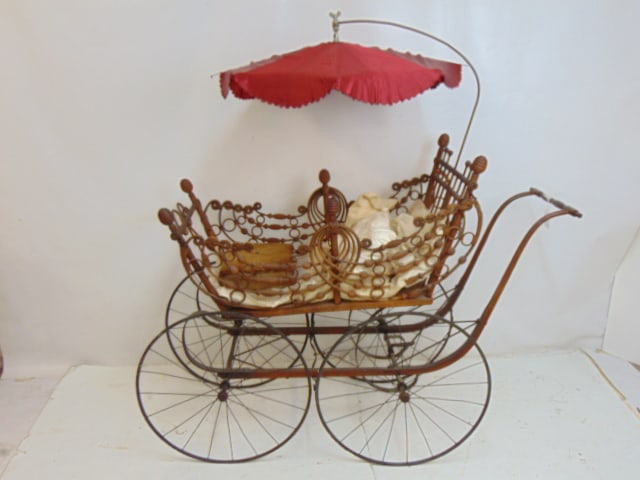 Antique baby carriage by Heywood Wakefield, decorative bentwood carriage on wrought iron base, with: Antique baby carriage by Heywood Wakefield, decorative bentwood carriage on wrought iron base, with parasol, 53" long, 21" wide, comes with small pillows, some loss, breaks.