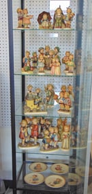 Large collection Hummel figurines, 28 pieces including 4 plates, and several oversized figurines.