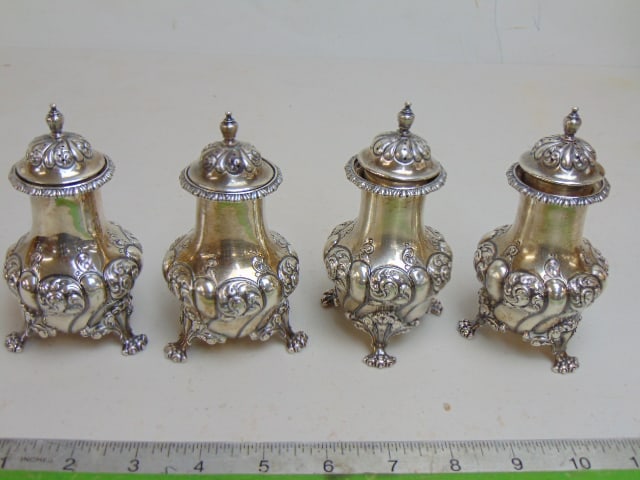4 Sterling shakers, Howard & Co, 1910, ornate designs, claw feet, 18.5 troy, 4.5" tall: 4 Sterling shakers, Howard & Co, 1910, ornate designs, claw feet, 18.5 troy, 4.5" tall