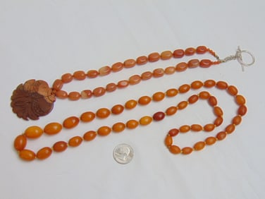 Jewelry. (2) Necklaces Butterscotch beaded necklace & stone necklace with carved pendant