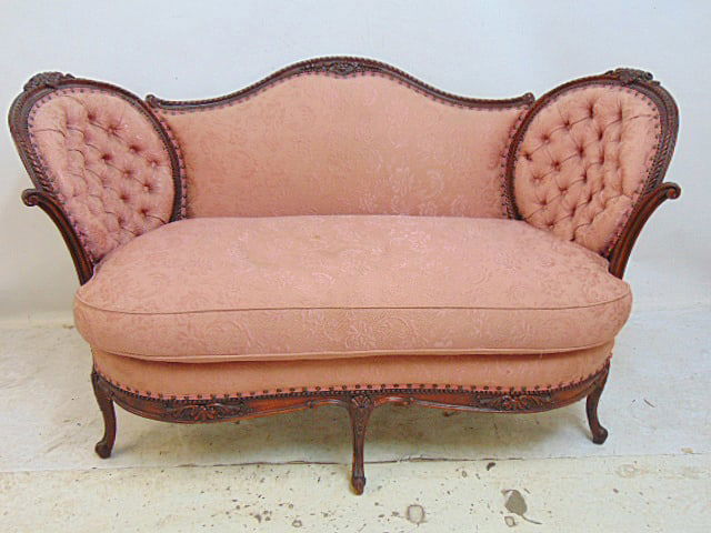 Upholstered loveseat with fancy carved frame, pink upholstery with tufted sides, 56" by 31", height: Upholstered loveseat with fancy carved frame, pink upholstery with tufted sides, 56" by 31", height is 33"