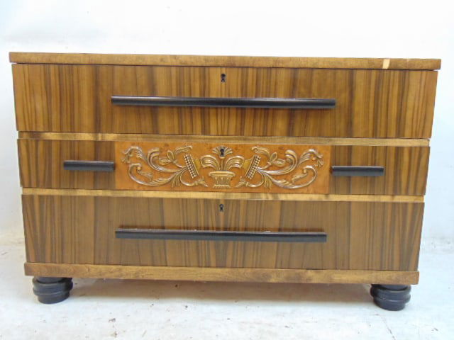 Small "Swedish Grace" art deco cabinet, triple drawer, center drawer has decorative carvings, small: Small "Swedish Grace" art deco cabinet, triple drawer, center drawer has decorative carvings, small veneer chip upper edge, 39 5/8" by 16.75", height is 25.5", no key