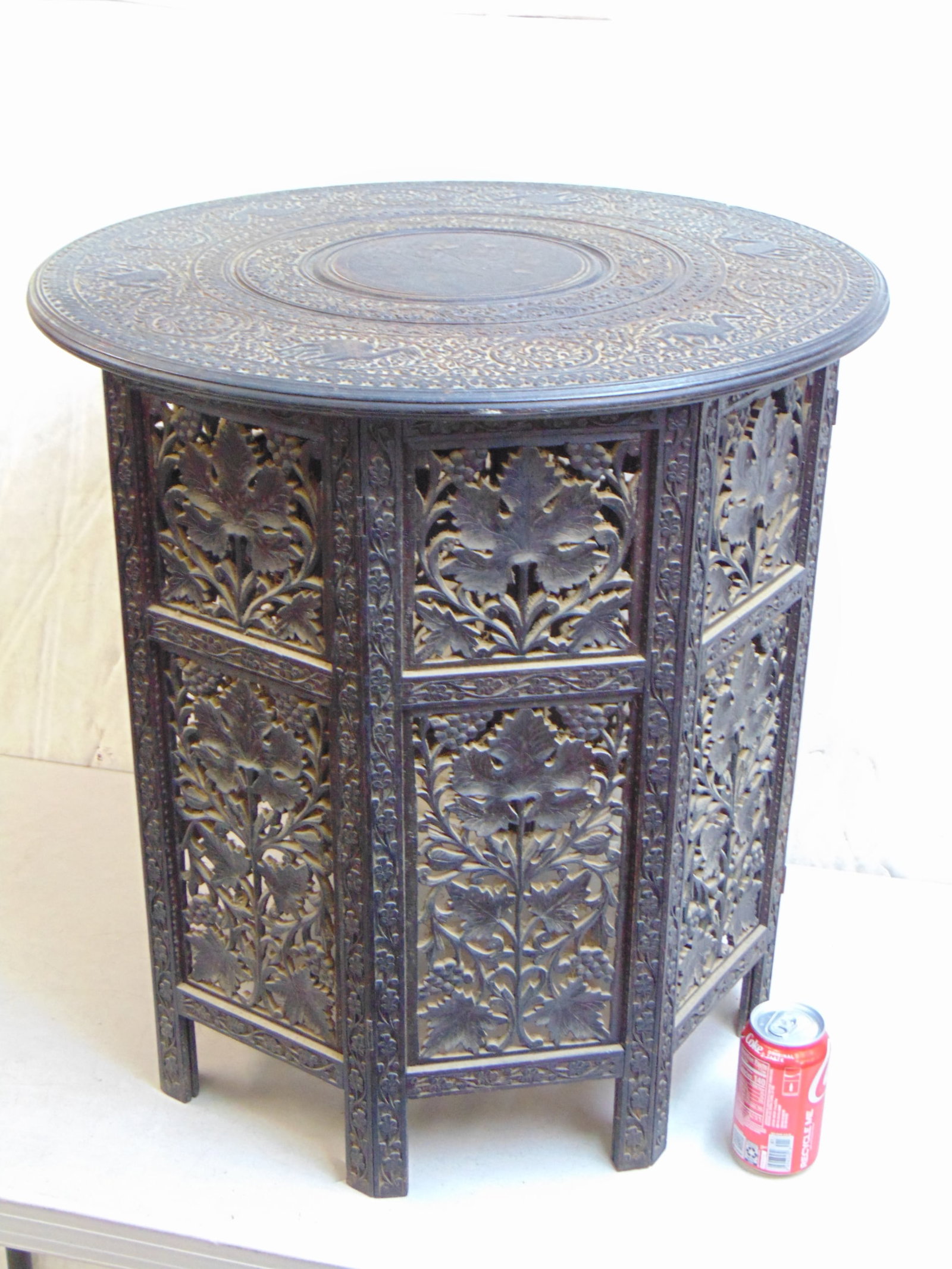 Moroccan carved side table with carved top, decorated with camels, intricately carved grape leaf pat: Moroccan carved side table with carved top, decorated with camels, intricately carved grape leaf pattern octagonal folding base, table is 23.75" in diameter, height is 24.5"