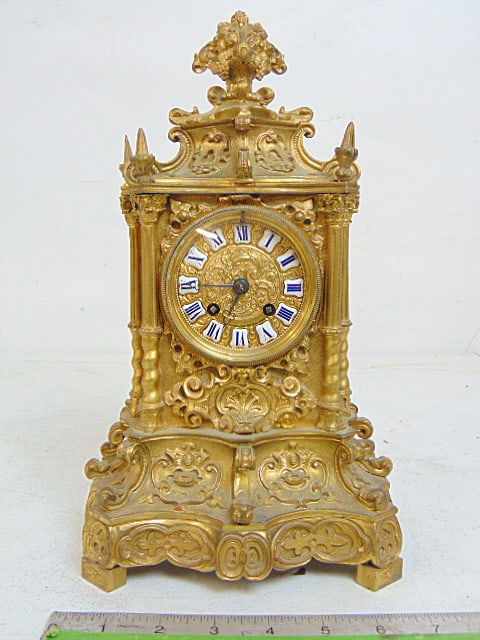 Ornate bronze mantle clock signed Norman, elaborate design with enameled numerals, clock is 12" tall: Ornate bronze mantle clock signed Norman, elaborate design with enameled numerals, clock is 12" tall