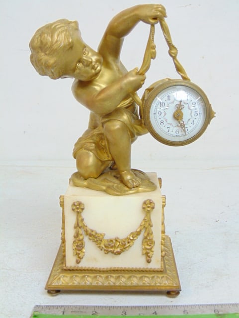 Bronze figural clock, putty holding drum, clock is in drum, gilt bronze on white marble base, clock: Bronze figural clock, putty holding drum, clock is in drum, gilt bronze on white marble base, clock is 4.75" by 4.75" (base), height is 10"