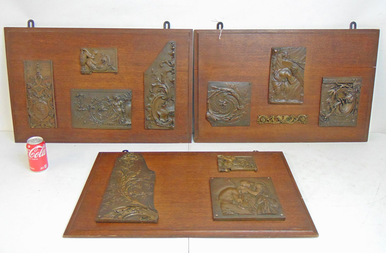 3 oak panels with applied bronze plaques, two panels hold 4 plaques, one holds 3, panels are 18.5": 3 oak panels with applied bronze plaques, two panels hold 4 plaques, one holds 3, panels are 18.5" by 29", plaques are submissions to various exhibitions, Ciselure d'Ornement, early 20th Century, exce