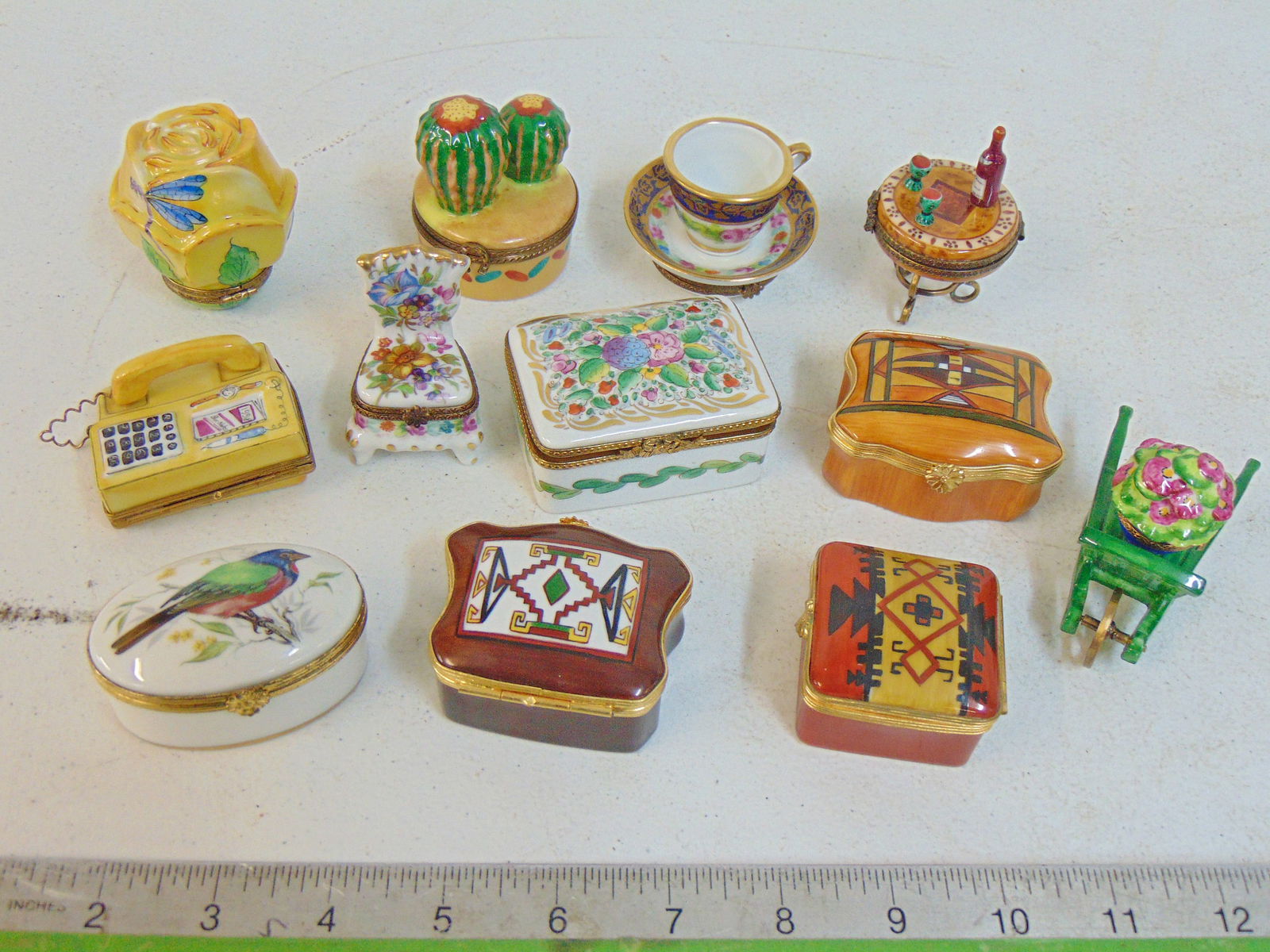 Collection of 12 porcelain Limoges boxes, various designs, several with bronze trim, includes: Collection of 12 porcelain Limoges boxes, various designs, several with bronze trim, includes cactus, phone, chair, floral, more, in good condition.