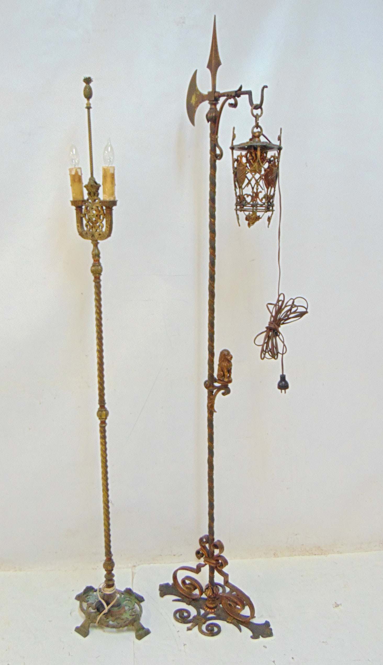 Two iron floor lamps, on lantern style, one torchier style, manner of Oscar Boch, torchier style: Two iron floor lamps, on lantern style, one torchier style, manner of Oscar Boch, torchier style floodlamp has pineapple finial, 70" & 64.25" tall