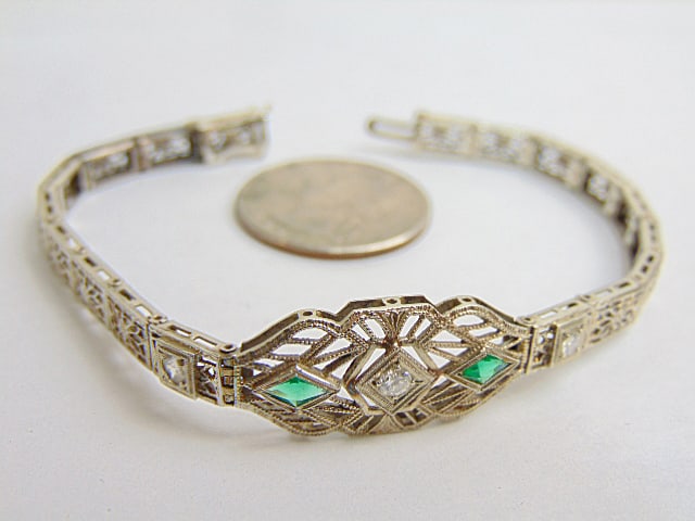 Jewelry. Vintage White Gold filigree bracelet w/ center diamond approx. 3mm flanked by two green: Jewelry. Vintage White Gold filigree bracelet w/ center diamond approx. 3mm flanked by two green gemstones flanked by two smaller diamonds approx. 2mm each, hallmark 14k, 8.60 grams, 7" length