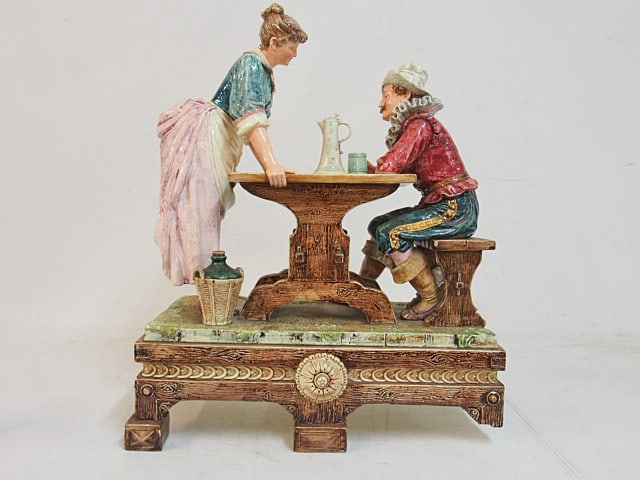 Majolica statue, bar maid standing at table with seated man, two legs on statue is missing, 17" by (1 of 4)