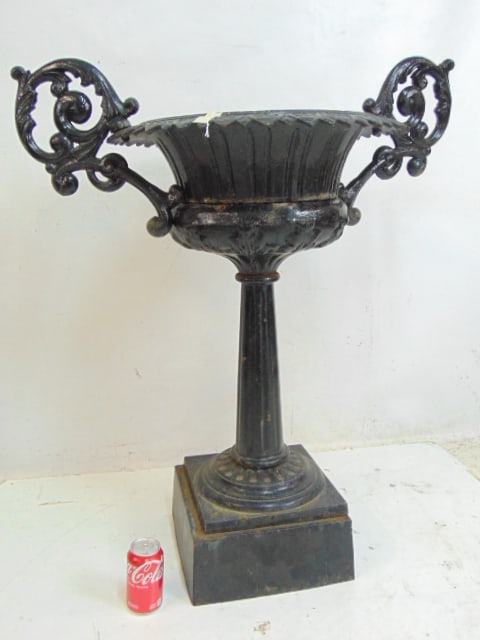 Large cast iron garden urn on column base, in black paint, sectional , bottom part is chained: Large cast iron garden urn on column base, in black paint, sectional , bottom part is chained together, top is 34" wide (including handles), height is 33.5"