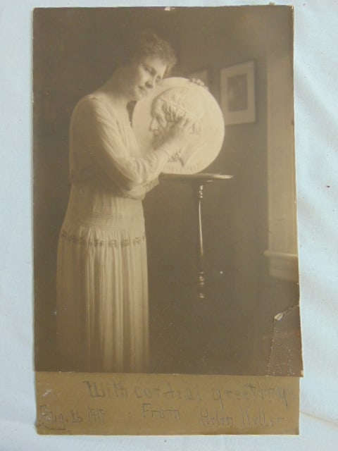 Photograph, Helen Keller touching a sculpted relief medallion, inscribed "With Cordial Greetings (1 of 5)