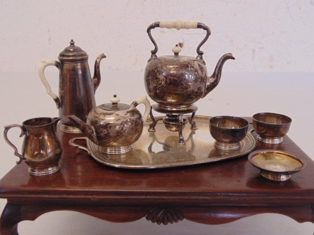 Miniature English silver tea set: Miniature English tea set consisting of a large kettle on burner base, coffee pot, tea pot, creamer, dish, two cups and charger, tea, coffee pots have bone handles Condition: handles are loose, large 