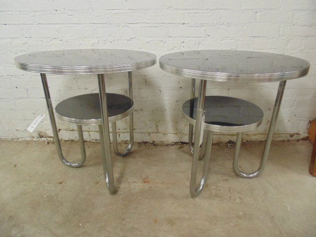 Pair chrome paperclip tables with black tops: Pair chrome paperclip tables with black tops, 24" diameter, 25.5" tall This lot is part of a collection of machine age chrome by makers Royalchrome, Chrometube, Warren MacArthur, Russel Wright, Wolfga