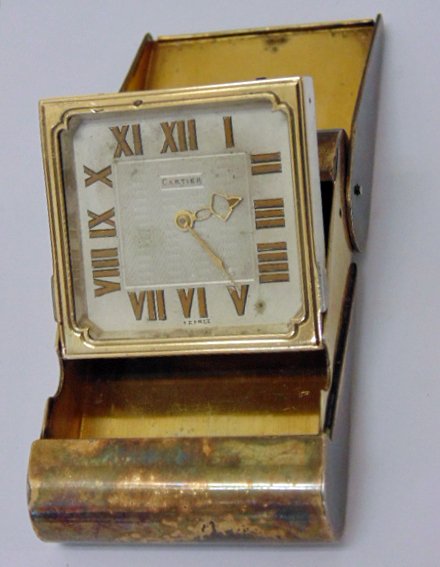 Silver travel clock in original case by Cartier: Silver travel clock in original case by Cartier, working condition. Serial number 2535, case in used condition, watch in good condition. 2.5" by 1.75", 5/8" thick. Note, all property herein offered fo