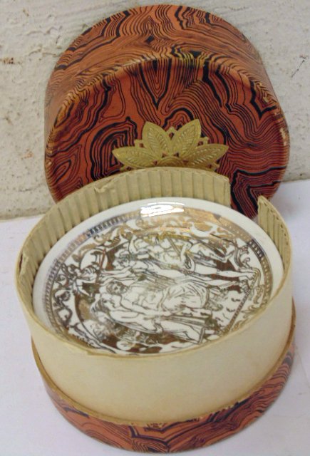 Set of 6 coasters in original container by Fornasetti: Set of 6 gilt porcelain coasters in original cardboard container labeled Fornasetti, Milano, porcelain gilt decorated coasters in condition, no chips or breaks, but gilt is worn in places, paper box h